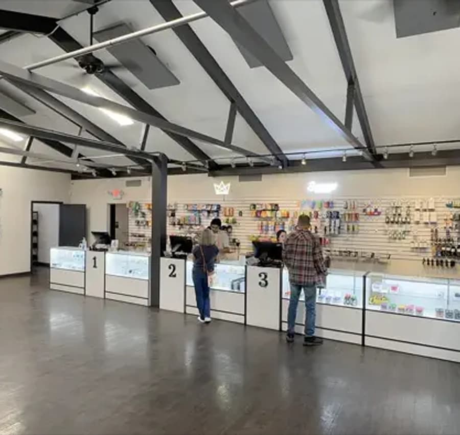 Nature's Wonder Apache Junction Dispensary Interior Interior of Nature's Wonder Apache Junction Dispensary, showing customers at the counter with staff assistance, shelves stocked with cannabis products, and a spacious, modern layout.