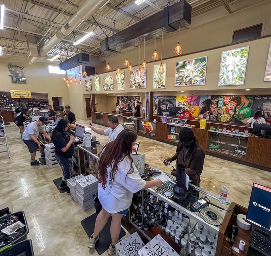 Nature's Wonder Coolidge Dispensary Interior Interior of Nature's Wonder Coolidge Dispensary, showing customers at the counter with staff assistance, shelves stocked with cannabis products, and a spacious, modern layout.